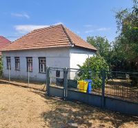 RD Otrokovce 1071m pozemok - Rodinný dom v Dolných Otrokovciach s plotom a záhradou na slnečnom pozemku.