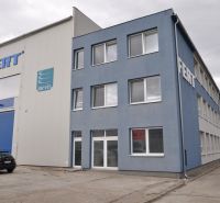 Priemyselná hala 2 500 m²  SKLADOVANIE, VÝROBA, LOGISTIKA - Výrobné priestory na Priemyselnej ulici v Galante so sivou budovou a parkoviskom.