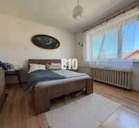 RODINNÝ DOM S GARÁZOU a pekným pozemkom - Spálňa s posteľou a podlahou s dreveným dekorom v rodinnom dome.