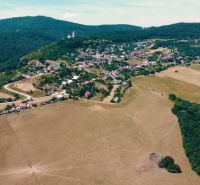 POZEMOK NA VÝSTAVBU PODHRADIE - Letecký pohľad na Podhradie s rodinnými domami a prírodou. Pozemky - bývanie.