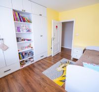 Na predaj 5i rodinný dom, novostavba, Vráble, pozemok 1200m2 - Detská izba v rodinnom dome s bielou skriňou, hnedou posteľou a podlahou s dreveným dekorom.