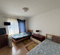 Na predaj zaujímavá nehnuteľnost na skok od Eurovea v k.ú. Nivy  - Spálňa v rodinnom dome s posteľami, televízorom a podlahou s dreveným dekorom.