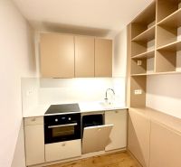 Na predaj úplne nový 1i byt od architekta v tichej časti Dúbravky - Kuchynská linka v 1-izbovom byte s podlahou s dreveným dekorom, svetlé skrinky.