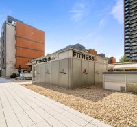 Na predaj PRIESTRANNÉ FITNESS CENTRUM na LUKRATÍVNEJ ADRESE RUŽINOVA - Exteriér Bratislava - Nivy, Trenčianska: Fitness centrum obklopené modernými budovami a spevnenými plochami.