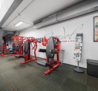 Na predaj PRIESTRANNÉ FITNESS CENTRUM na LUKRATÍVNEJ ADRESE RUŽINOVA - Posilňovacie stroje v obchodných priestoroch so zrkadlami a kobercovou podlahou.