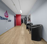 Na predaj PRIESTRANNÉ FITNESS CENTRUM na LUKRATÍVNEJ ADRESE RUŽINOVA - Interiér obchodných priestorov s podlahou s dreveným dekorom a pohodlnými kreslami.
