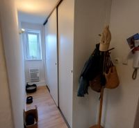 Krásny 2 izbový byt s balkónom- Vargové pole. - Chodba v 2-izbovom byte s podlahou s dreveným dekorom a vstavanými skriňami.