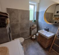 Krásny 2 izbový byt s balkónom- Vargové pole. - Kúpeľňa v 2-izbovom byte s okrúhlym zrkadlom a praktickým úložným priestorom.