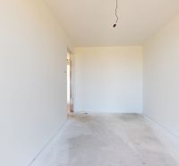 KRÁĽOVÁ PRI SENCI – SKOLAUDOVANÁ novostavba 4i RD v štandarde - Biela miestnosť čakajúca na dokončenie v rodinnom dome, betónová podlaha, neosadené svietidlo.