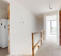 KRÁĽOVÁ PRI SENCI – SKOLAUDOVANÁ novostavba 4i RD v štandarde - Interiér rodinného domu s bielymi stenami a nezakrytou konštrukciou schodiska.