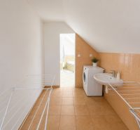 6-izbový rodinný dom v Šamoríne | 201 m² | pozemok 451 m² | - Práčovňa v rodinnom dome s práčkou, umývadlom a sušiakom na bielizeň.
