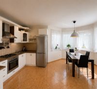 6-izbový rodinný dom v Šamoríne | 201 m² | pozemok 451 m² | - Kuchyňa v rodinnom dome s bielymi skrinkami a jedálenským stolom.