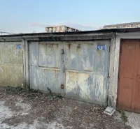 18 m2 Garáž na Sliačskej ulici v Bratislave - Opustené garáže v Bratislave - Novom Meste s opadanou omietkou a plechovými dverami.