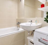 Slnečný 2-izb. byt, terasa a balkón, Stupava, V. Šikulu - Kúpeľňa v 2-izbovom byte s vaňou, umývadlom a práčkou.