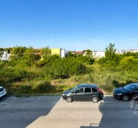 Slnečný 2-izb. byt, terasa a balkón, Stupava, V. Šikulu - Cesta s autami pri ulici Vincenta Šikulu v meste Stupava, obklopená zeleňou.