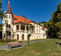 Slnečný 2-izb. byt, terasa a balkón, Stupava, V. Šikulu - Historická budova v Stupave na ulici Vincenta Šikulu obklopená zeleňou a chodníkom.