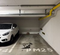 Zariadený 2-izbový byt s loggiou na Kadnárovej ulici - Podzemné parkovacie miesto v 2-izbovom byte s označením PM25, vedľa bieleho vozidla.