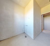NOVOSTAVBA 3 izb. BYT 73 m2 | BALKÓN | SENEC - Dlhá ul. - Nezariadený priestor v 3-izbovom byte s omietnutými stenami a betónovou podlahou.