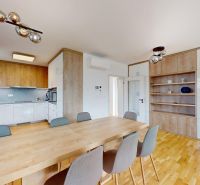 Nadštandardný 5-izbový rodinný dom - Orešianky - Kuchyňa v rodinnom dome s drevenými skrinkami a jedálenským stolom, elegantné osvetlenie.