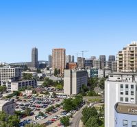 Exkluzívny 3-izbový byt v Jarabinkách s veľkou terasou  - Panoráma mesta Bratislava - Nové Mesto z ulice Jarabinková s výhľadom na parkovisko.