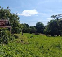 Na predaj pozemok pri Prešove - Zelené pozemky na bývanie v Žehni obklopené stromami a modrou oblohou.