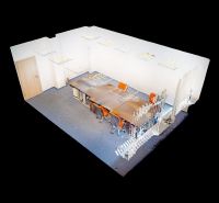 Kancelárie od 25,7 m² s parkovaním, recepcia 24/7 – Košická ul., Nivy - 3D model kancelárie s dlhou stolovou zostavou a oranžovými stoličkami, kobercová podlaha.