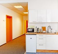 Kancelárie od 25,7 m² s parkovaním, recepcia 24/7 – Košická ul., Nivy - Kuchynka v kanceláriách s bielymi skrinkami, kobercom, vybavená spotrebičmi a dreveným dekorom.