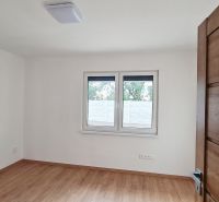 / Novostavba, moderný bungalov, dokončený na kľúč  - Izba v rodinnom dome s podlahou s dreveným dekorom a veľkým oknom.