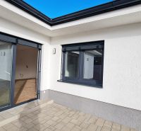 / Novostavba, moderný bungalov, dokončený na kľúč  - Exteriér rodinného domu v Senci s terasou a veľkými sklenenými dverami.