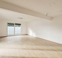 / Novostavba, moderný bungalov, dokončený na kľúč  - Priestranný interiér rodinného domu s podlahou s dreveným dekorom a veľkým oknom.