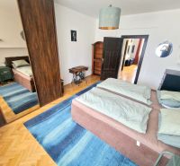 Veľký 3i byt, vysoké stropy,  pivnica, garáž, Murgašova, Staré Mesto - Spálňa v 3-izbovom byte s posteľou, zrkadlovou skriňou a modrým kobercom.