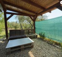 ? Predaj záhradkárskej chatky – Vinica, Lučenec – 20 000 € - Drevená pergola s posedením na chate vo Vinici v Lučenci obklopená zeleňou.