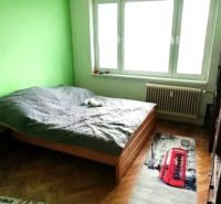 1- izbový byt - Košice - Juh, Ostravská ulica - Spálňa v 1-izbovom byte so zelenou stenou a podlahou s dreveným dekorom.