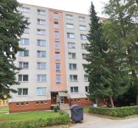 Priestranný 2-izbový byt - Bytový dom na Tatranskej ulici v Považskej Bystrici, obklopený zeleňou a stromami.