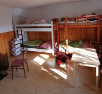 Dva vidiecke domy na pozemku 1,6ha D. Strehová (Prieloh), V. Krtíš. - Poschodové postele, krbové kachle a nábytok v miestnosti v rodinnom dome.
