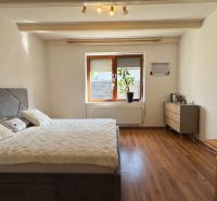 NA PREDAJ rodinný dom vo Svätoplukove - Spálňa v rodinnom dome s drevenou podlahou, posteľou a komodou.