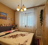 NA PREDAJ rodinný dom v Jelšovciach - EXKLUZÍVNE - Spálňa s posteľou, drevenými stenami a dekoráciami, vhodná pre rodinný dom.