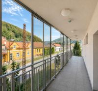 Na predaj 3i byt s 2 balkónmi a parkovaním v Trenčianskych Tepliciach - Zasklený balkón v Trenčianskych Tepliciach na ulici Gen. M. R. Štefánika, okolité domy.