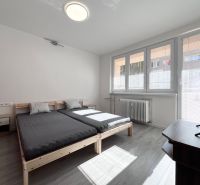 NA PRENÁJOM! Slnečný a zariadený 3i byt 68 m2, ul. Švermova, Trenčín - Svetlá spálňa s posteľou, TV a podlahou s dreveným dekorom v 3-izbovom byte.