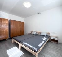NA PRENÁJOM! Slnečný a zariadený 3i byt 68 m2, ul. Švermova, Trenčín - Spálňa s posteľou, drevenými skriňami a podlahou s dreveným dekorom v 3-izbovom byte.