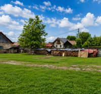 Stavebný pozemok 651 m² v obci Belá-Dulice – tichá lokalita - Pozemky na bývanie v Belá-Duliciach s trávnikom a drevárňou v pozadí.