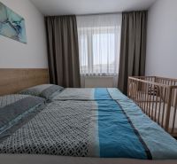 MODERNÁ ZARIADENÁ NOVOSTAVBA  takmer v centre - MAHULANKA - Svetlá spálňa s posteľou a detskou postieľkou v 2-izbovom byte.