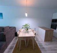 MODERNÁ ZARIADENÁ NOVOSTAVBA  takmer v centre - MAHULANKA - Jedáleň v 2-izbovom byte s jedálenským stolom a podlahou s dreveným dekorom.