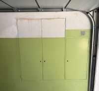 Garáž ul. Eisnerova, Devínska Nová Ves - Garáž v bielej a zelenej farbe má členené úložné skrinky.