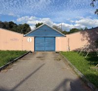 Garáž ul. Eisnerova, Devínska Nová Ves - Garáže na Eisnerovej ulici v Bratislave - Devínskej Novej Vsi, s modrou bránou a graffiti.