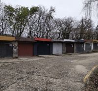 Garáž Púpavova, Karlova Ves + pivnica - Staršie garáže pri Púpavovej ulici, pokryté stromami a prázdnou cestou.