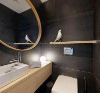 SKY PARK - dizajnový byt - výhľady do zelene  - Kúpeľňa so zrkadlom, bielym umývadlom a tmavými obkladmi v 3-izbovom byte.