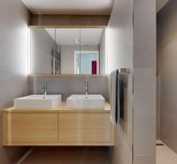 SKY PARK - dizajnový byt - výhľady do zelene  - Kúpeľňa v 3-izbovom byte so štýlovými umývadlami, zrkadlom a dreveným dekorom.