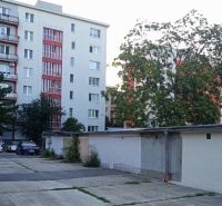 Garáž Haburská ul., Ružinov s pozemkom - Garáže na Haburskej ulici v Bratislave - Ružinov, v pozadí obytné domy a stromy.