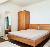 5-izb. dvojpodlažný rodinný dom, Rovinka - Spálňa v rodinnom dome s drevenou posteľou, skriňou, zrkadlom a stojacou lampou.